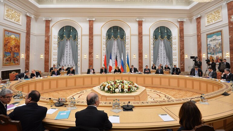 A large plenary hall with tables arranged in a circle.