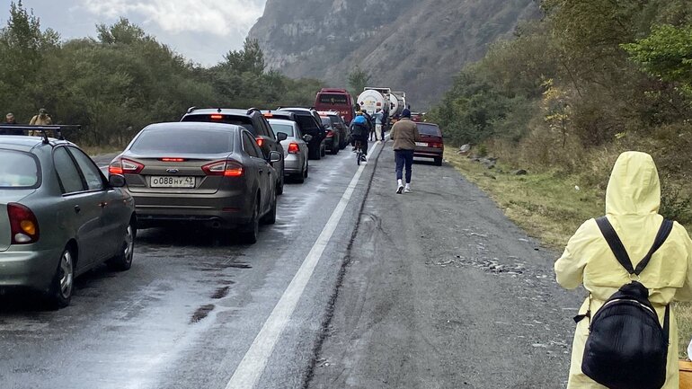 In September 2022, cars waited in a long line at the Verkhny Lars–Darial Gorge border crossing between Russia and Georgia, with people walking beside the vehicles and the mountains visible in the background.