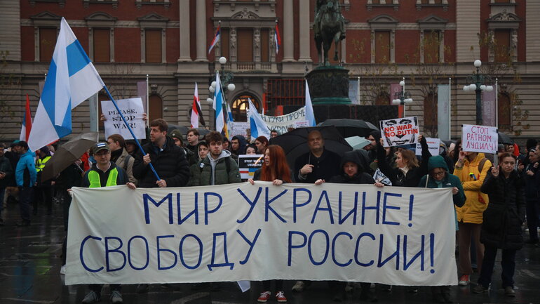 A demonstration with many people holding flags and banners.