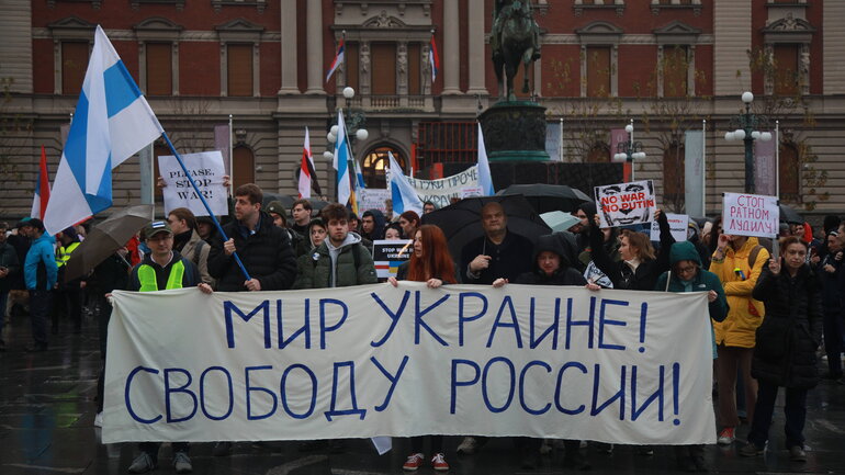 A demonstration with many people holding flags and banners.