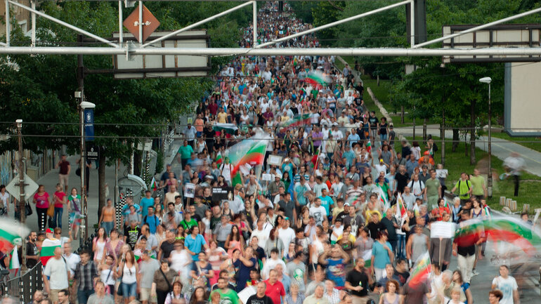 Tausende von Menschen, viele mit bulgarischen Flaggen, protestieren in Sofia gegen die Regierung.