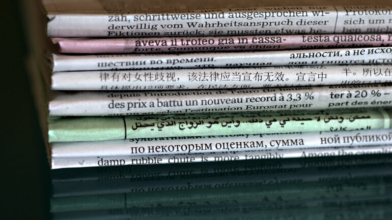 Newspaper cuttings in many written languages.
