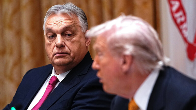 Viktor Orbán steht im Fokus des Bildes und sieht den grade sprechenden Donald Trump mit ernstem Blick an.